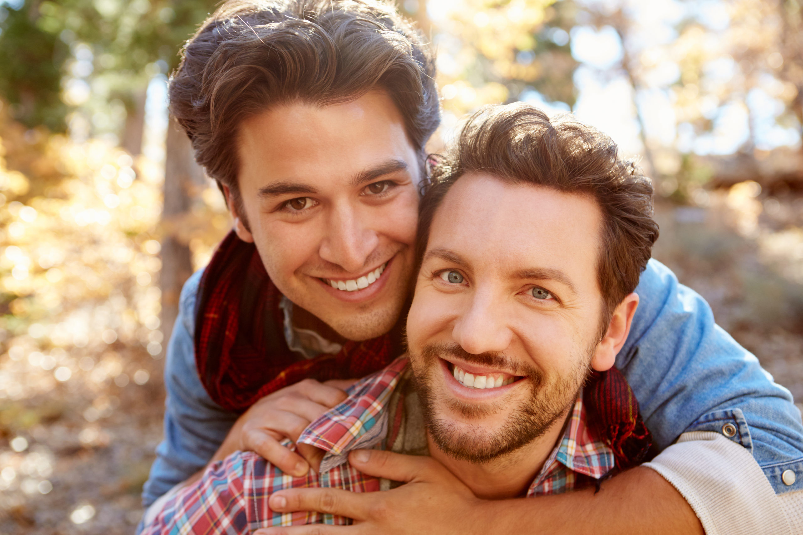 Portrait,Of,Gay,Male,Couple,Walking,Through,Fall,Woodland